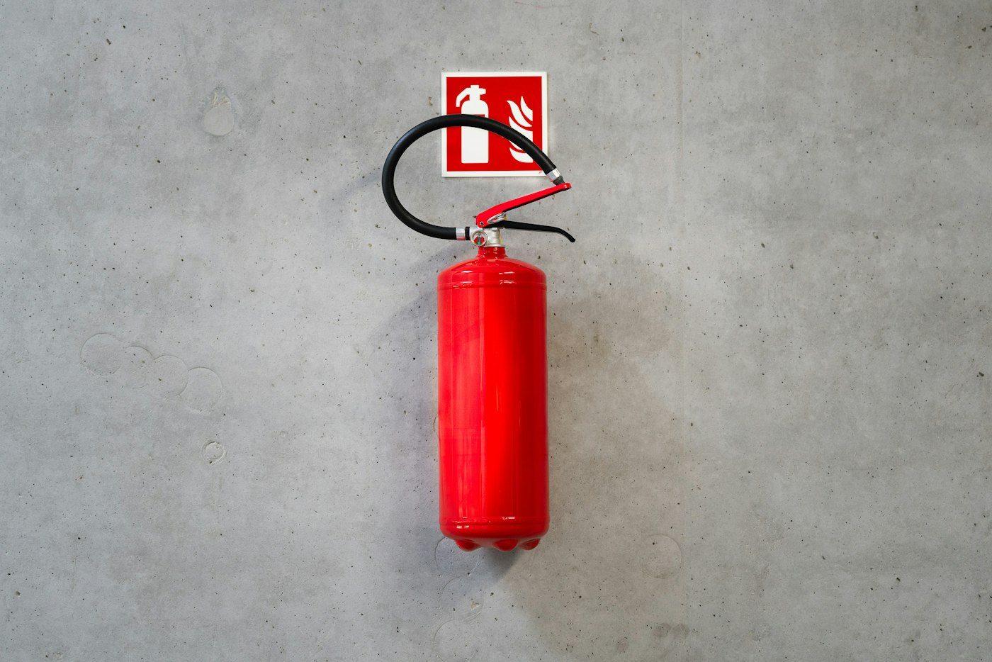 Feuerlöscher mit Hinweisschild an einer Wand