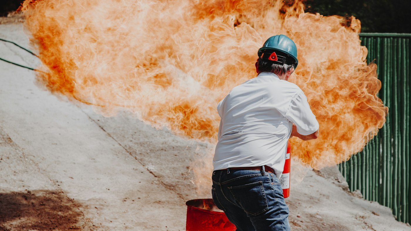 Löschübung: Ein Teilnehmer löscht ein Übungsfeuer mit dem Feuerlöscher